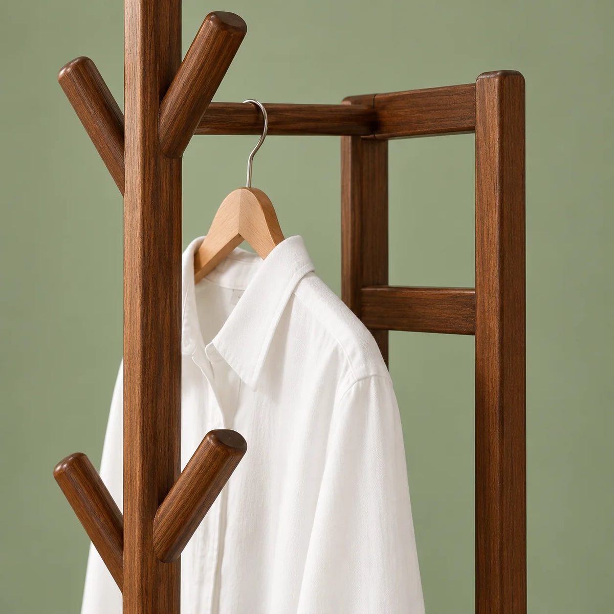 Détail de la barre à cintre et du cadre en bois foncé avec chemise blanche