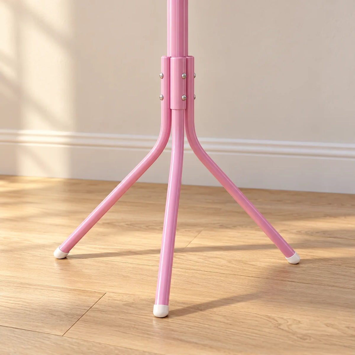 Gros plan sur la base tripode rose à embouts blancs du porte-manteau perroquet