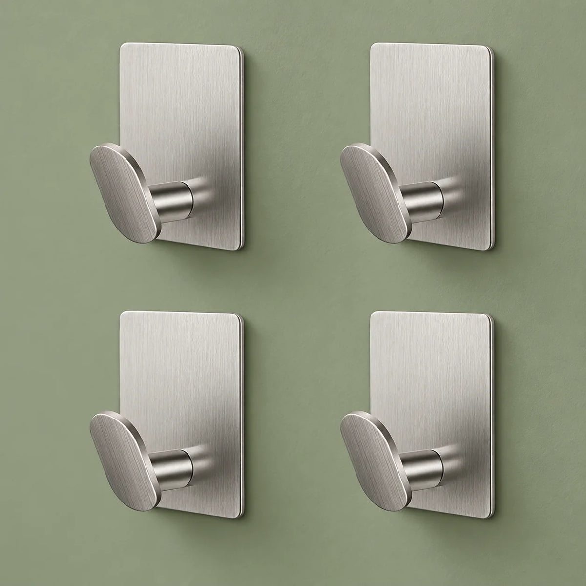 Les quatre crochets argent du lot disposés sur un fond vert sauge