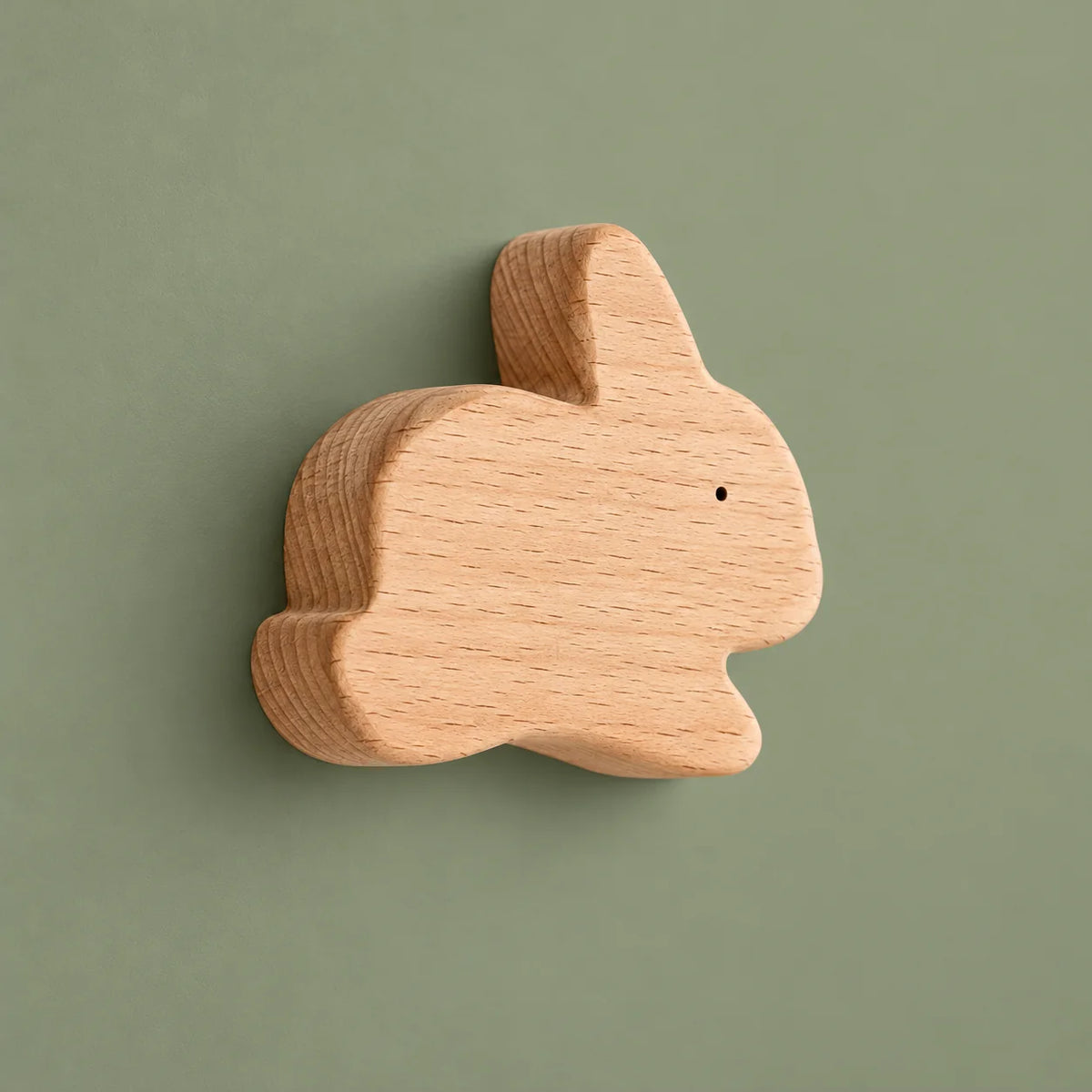 Patère murale lapin en bois naturel présentée seule sur fond vert sauge