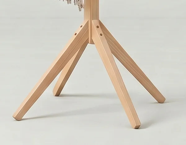 Détail du piètement évasé et des fixations du porte-manteau en bois clair