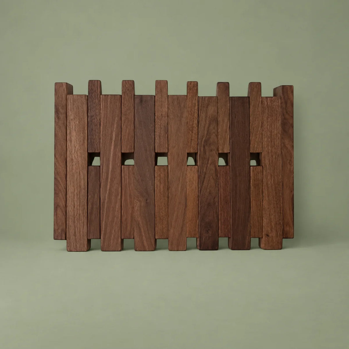 Porte-manteau mural carré large en bois foncé et crochets fermés sur fond vert sauge