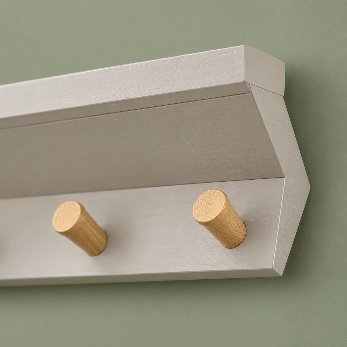 Détail de l’extrémité droite du porte-manteau gris et de ses patères en bois naturel