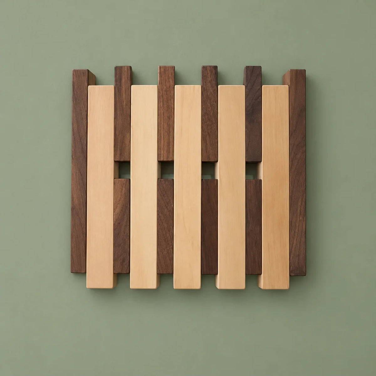 Petit porte-manteau mural bicolore, bois clair et foncé, sur fond vert sauge