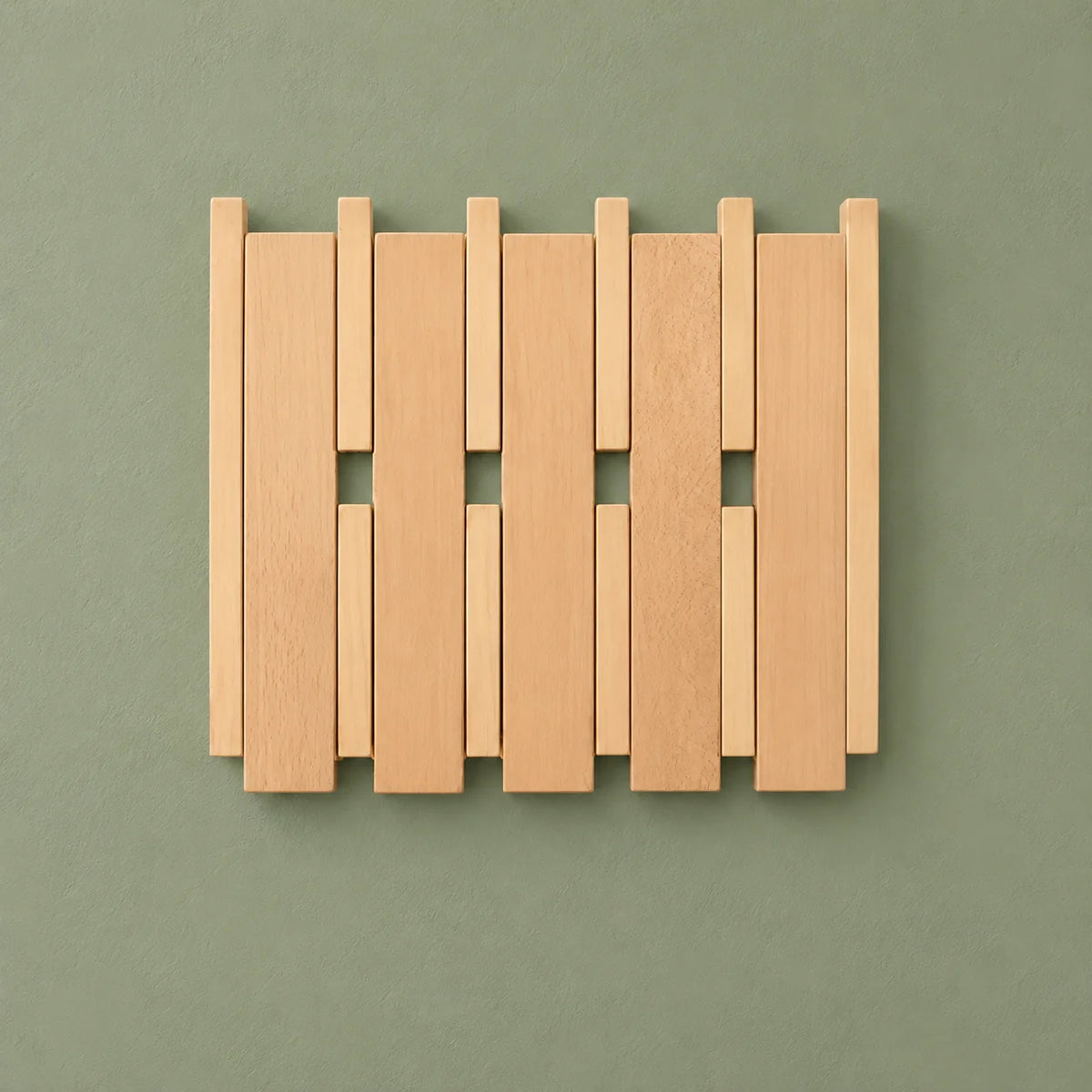 Petit porte-manteau mural carré en bois clair et crochets fermés sur fond vert sauge