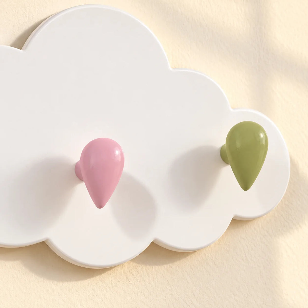 Gros plan des patères goutte rose et verte en relief sur le nuage blanc