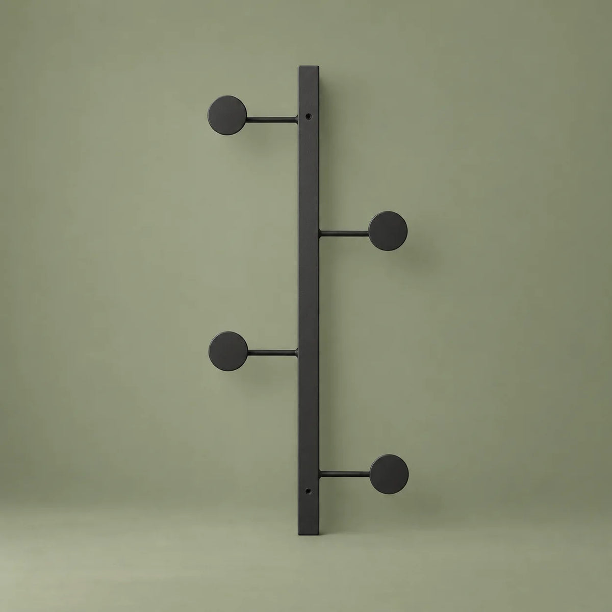 Vue complète du porte-manteau mural noir à quatre crochets sur fond vert sauge