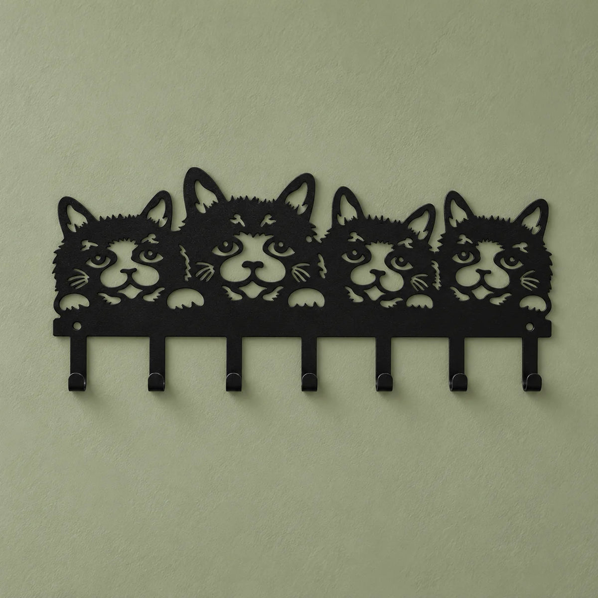 Porte-manteau mural noir à quatre chats présenté de face sur fond vert sauge