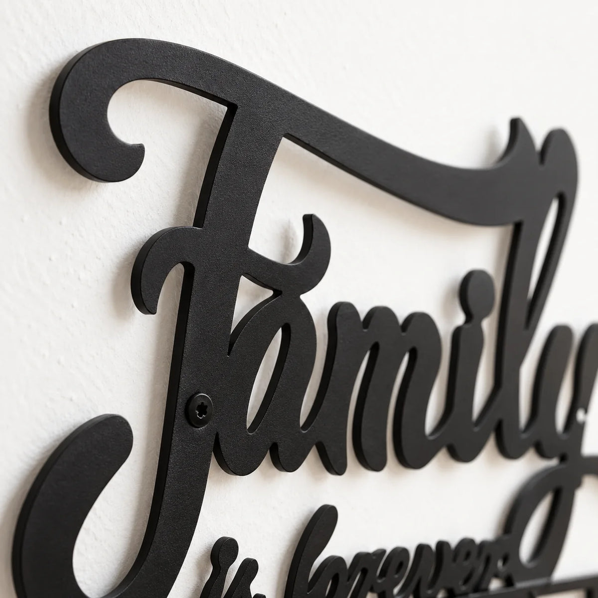 Détail de la découpe et de la fixation du lettrage Family en métal noir