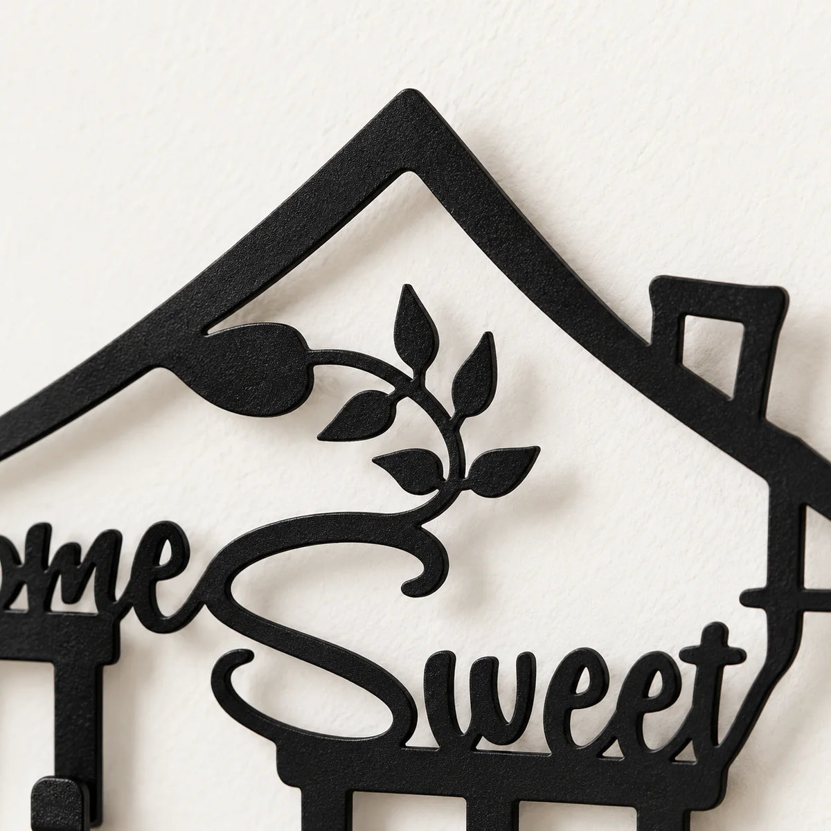 Détail du toit, de la cheminée et des feuilles en fer noir du porte-manteau Home Sweet Home