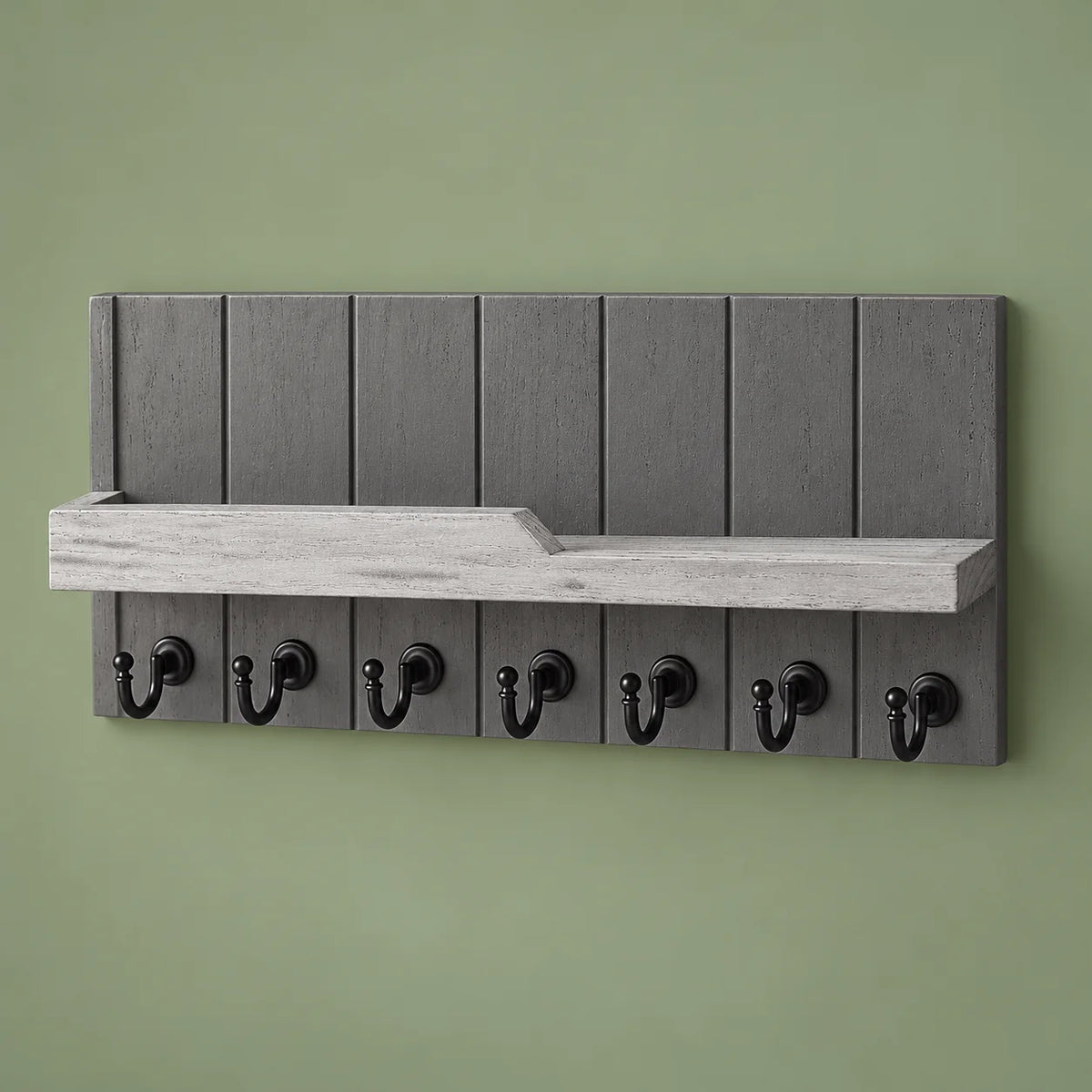 Vue complète du porte-manteau mural gris à sept crochets noirs sur fond vert sauge