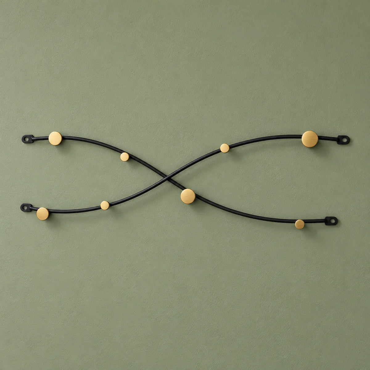 Porte-manteau mural vague croisée noir et doré, vue complète sur fond vert sauge
