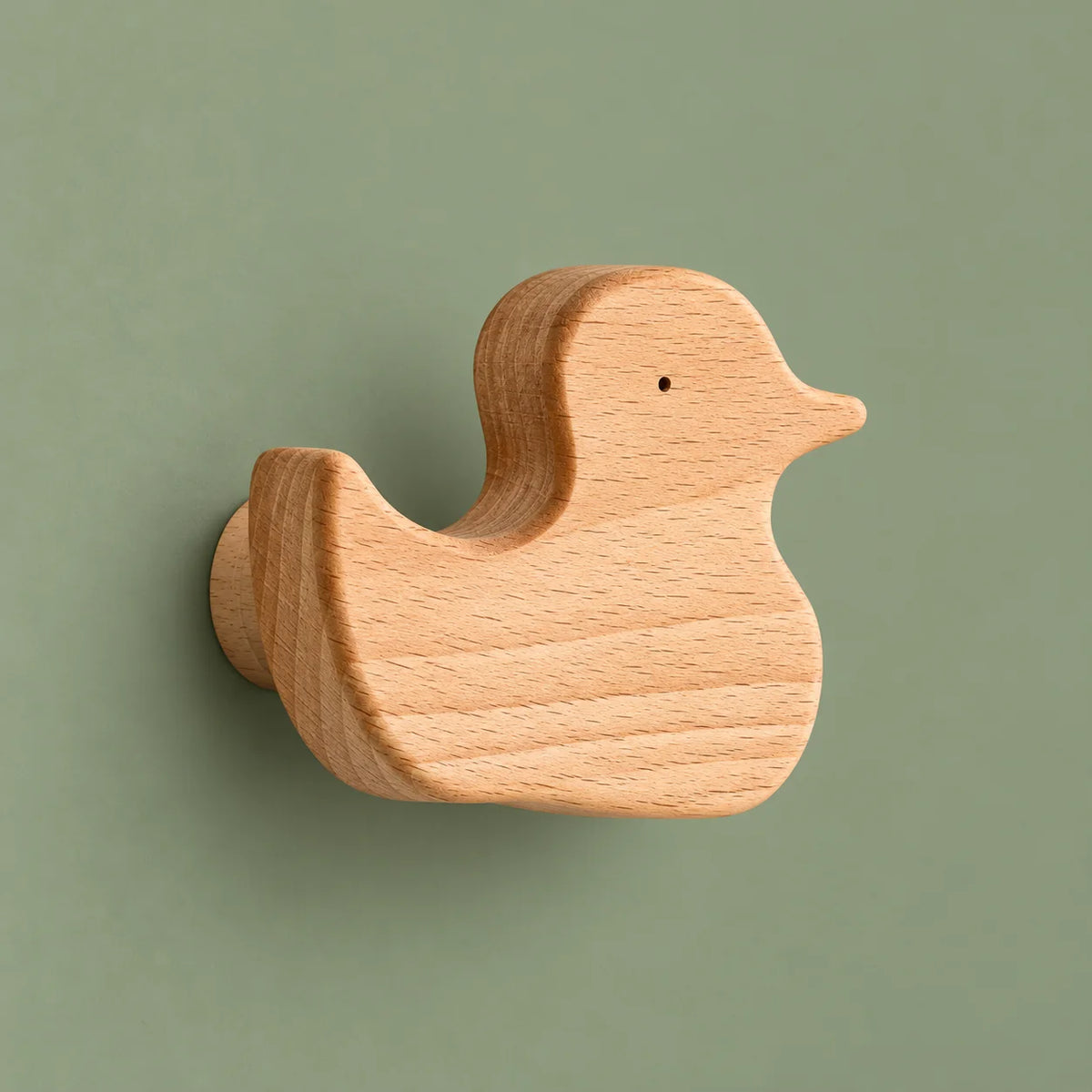 Patère murale canard en bois clair naturel présentée seule sur fond vert sauge