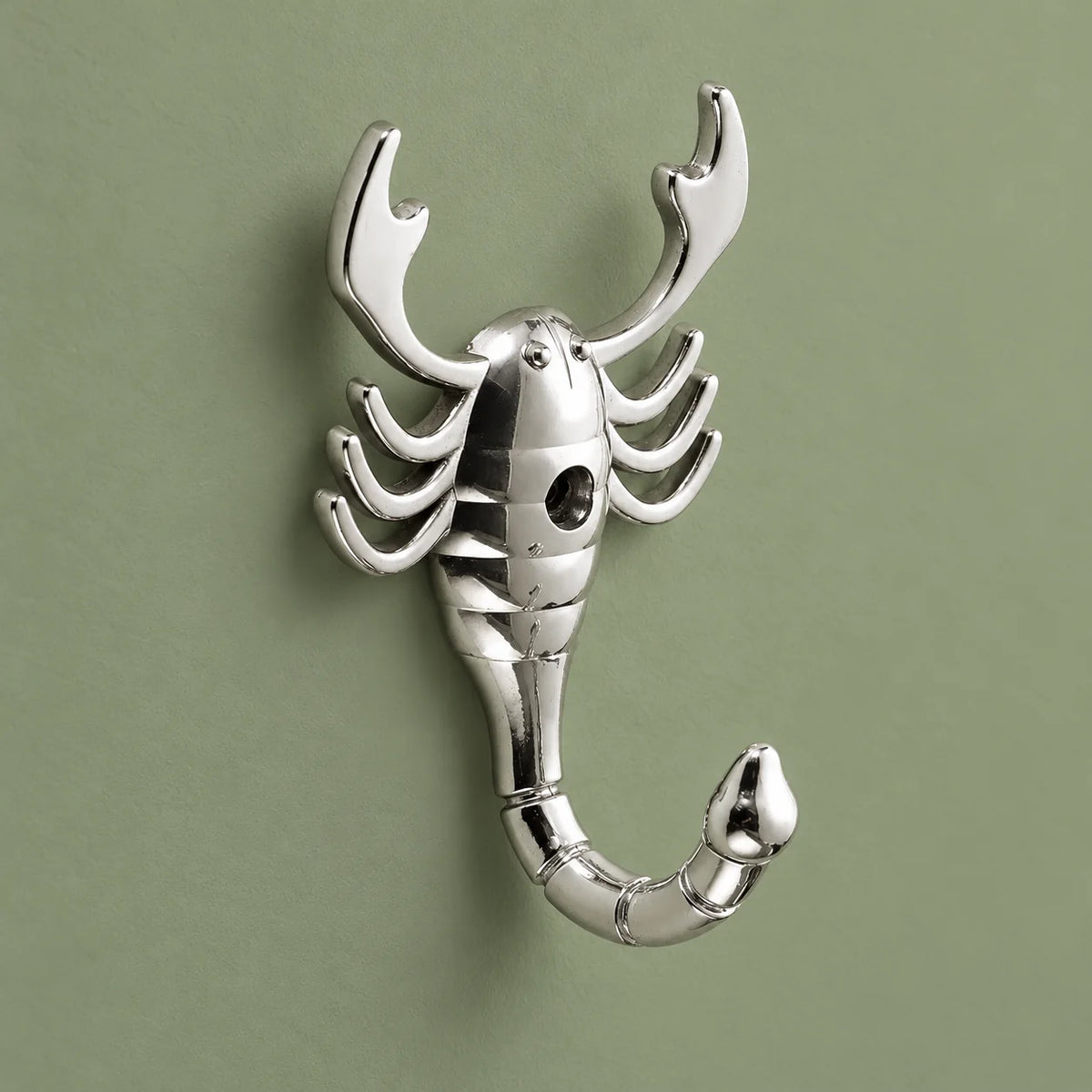 Patère scorpion chromée argent vue entière sur fond vert sauge