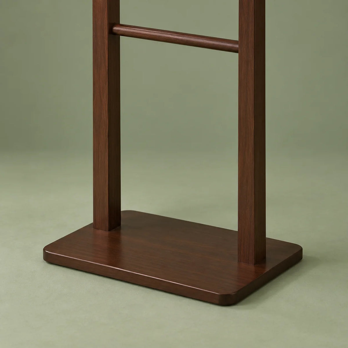 Détail du socle plat et des deux montants du porte-manteau en bois foncé