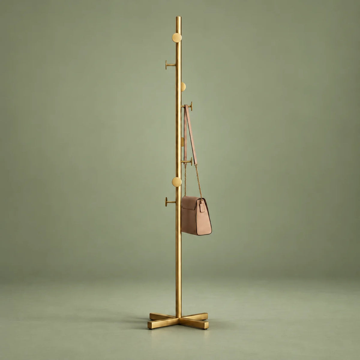 Porte-manteau sur pied doré entier avec base croisée sur fond vert sauge