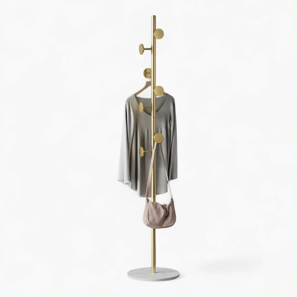 Photo originale du porte-manteau champignon doré à base blanche et vêtements suspendus
