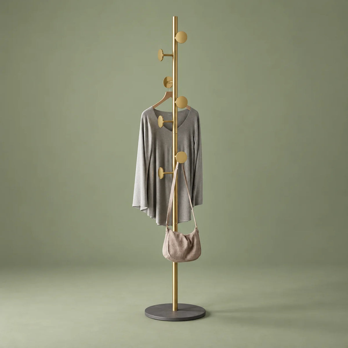 Porte-manteau doré à base grise, vue entière sur fond vert sauge