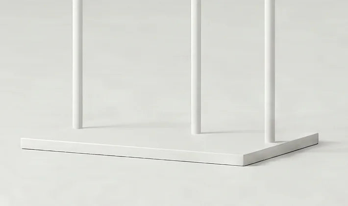 Détail de la base rectangulaire blanche et des trois montants blancs du porte-manteau