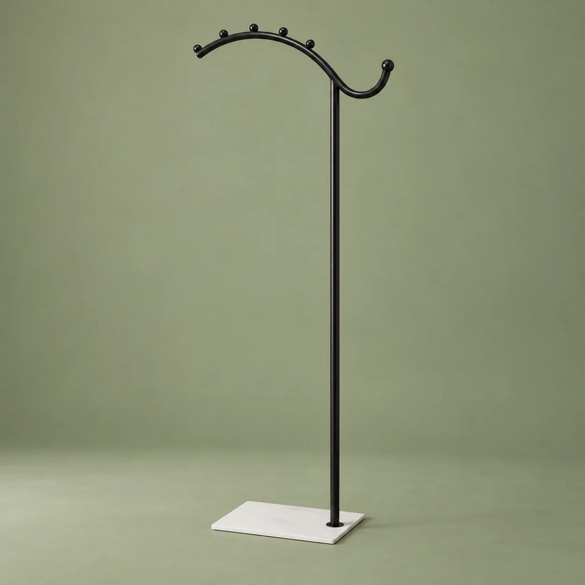 Porte-manteau voûté noir à socle blanc, vue complète sur fond vert sauge