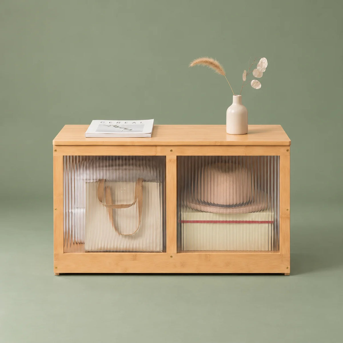 Vue de face du meuble à chaussures en bambou bois clair à deux panneaux cannelés sur fond vert sauge