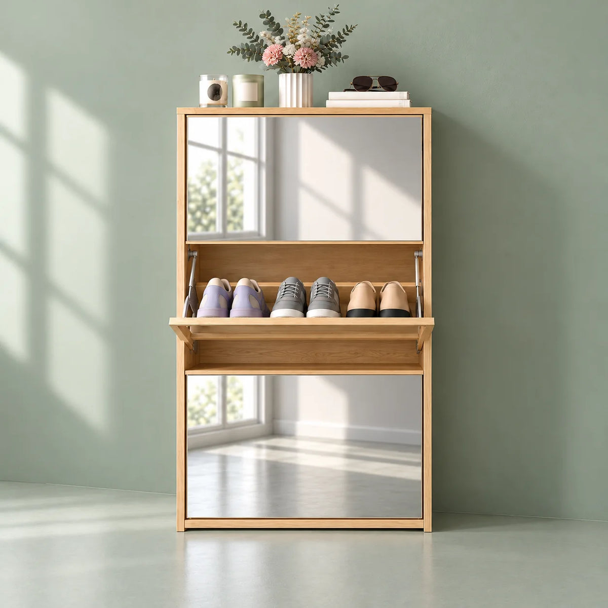 Vue de face du meuble à chaussures en bois clair avec miroirs sur fond vert sauge
