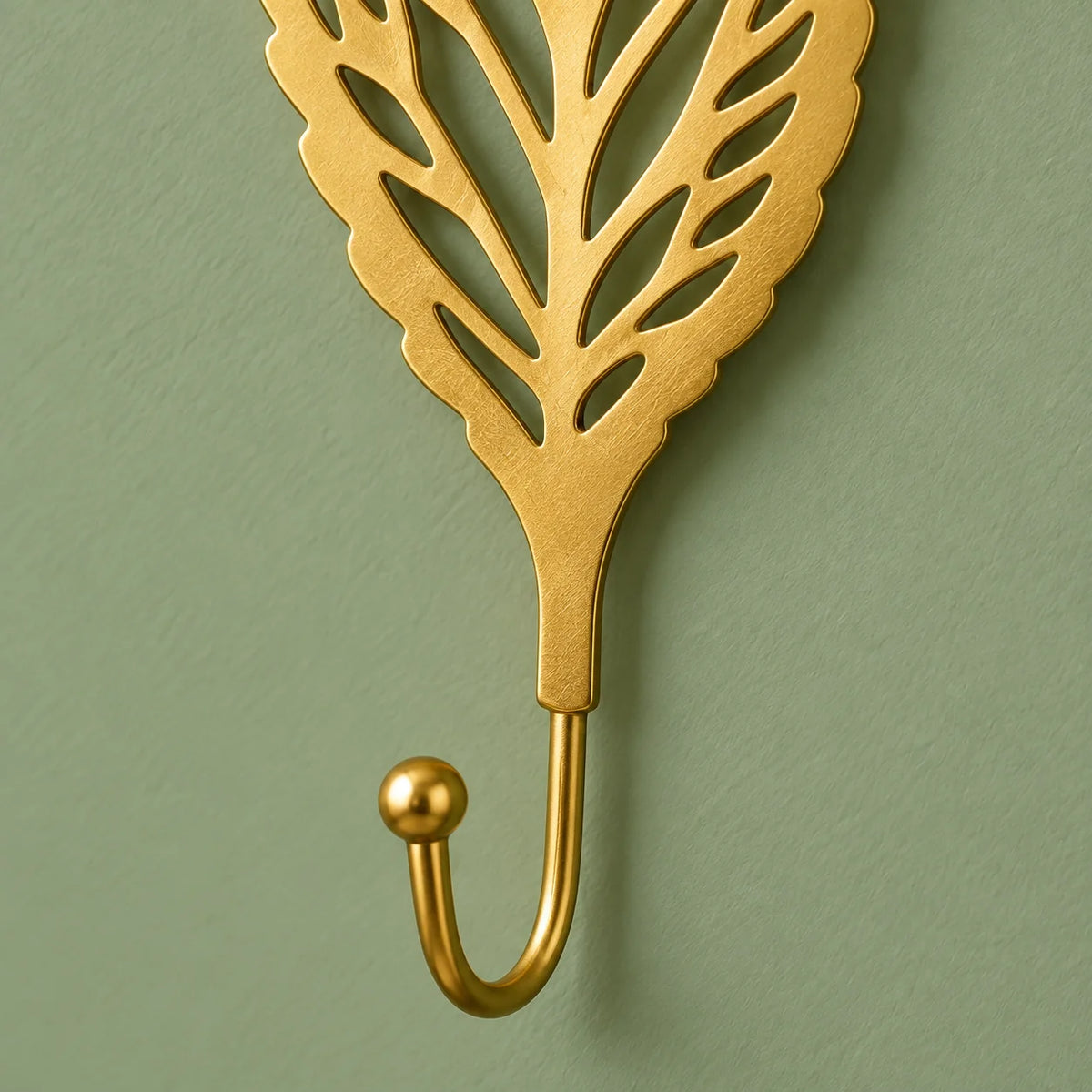 Détail du crochet recourbé de la patère Feuille ronde dorée