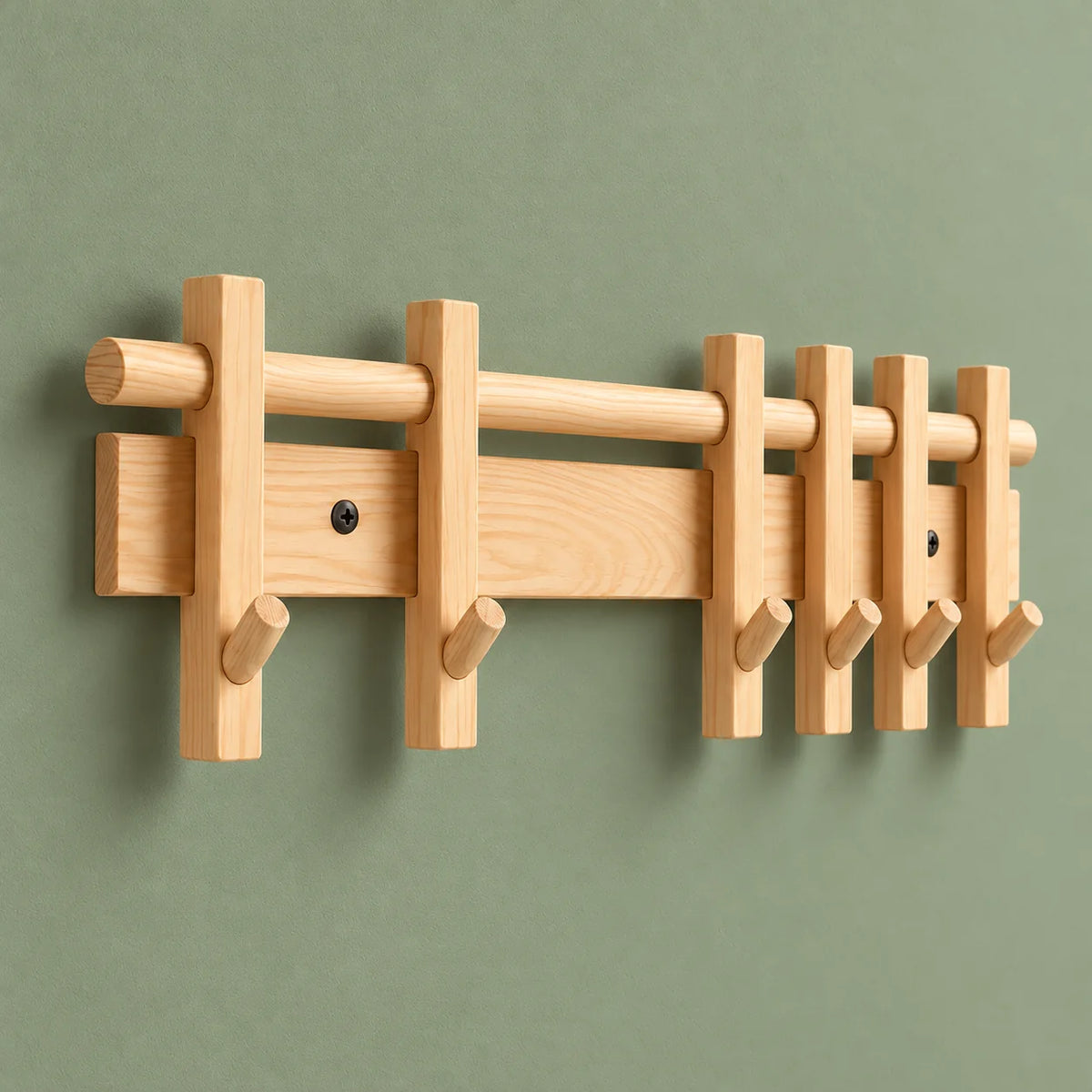 Vue de trois quarts du porte-manteau mural en bois clair sur mur vert sauge