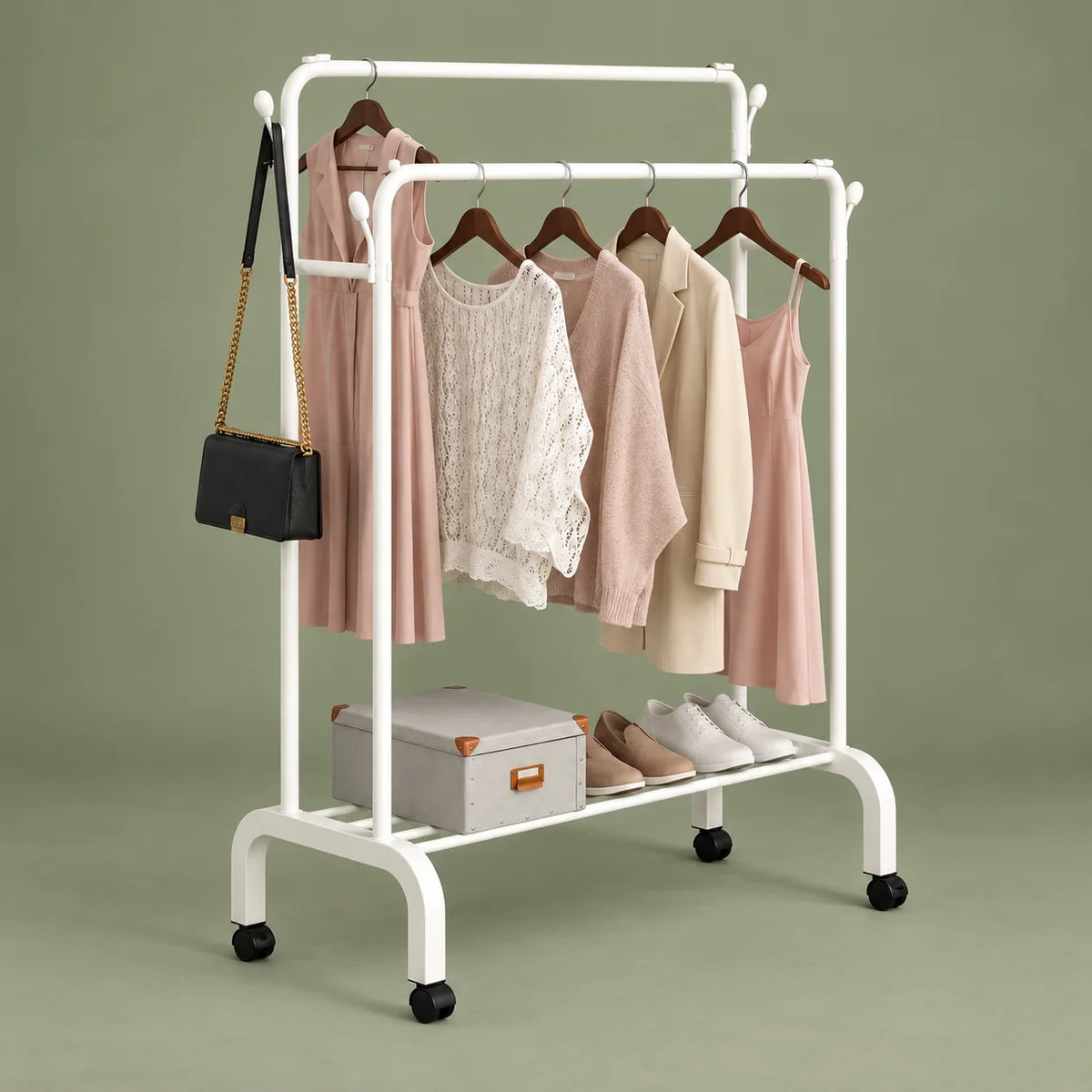 Vue en angle du portant dressing blanc sur roulettes et de son étagère sur fond vert sauge