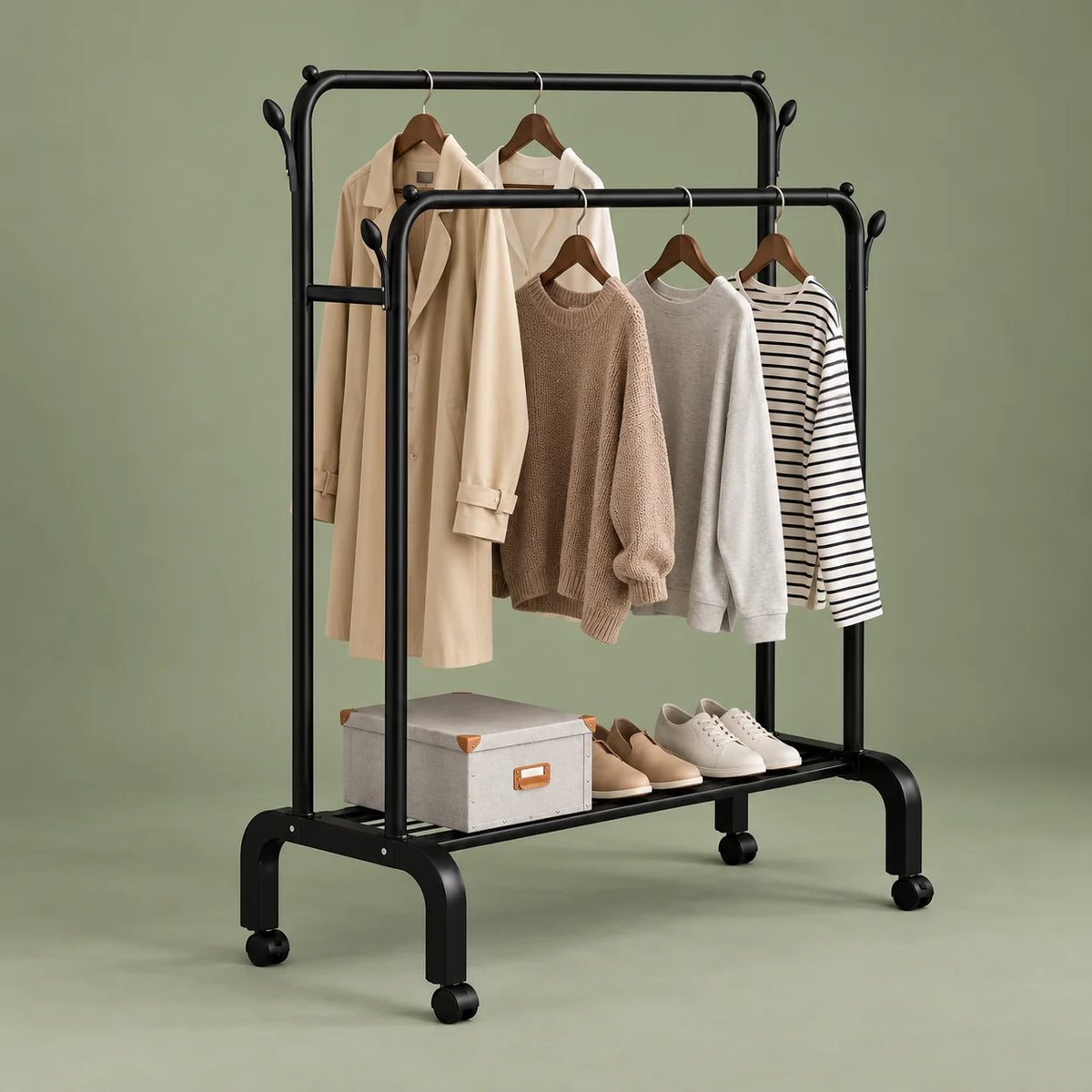 Vue en angle du portant dressing noir sur roulettes et de son étagère sur fond vert sauge