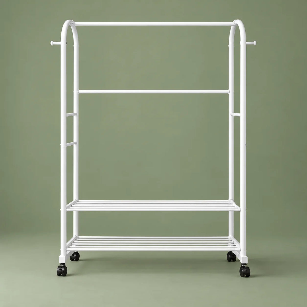 Vue de face du portant blanc Luxe, étagères ajourées et roulettes, sur fond vert sauge