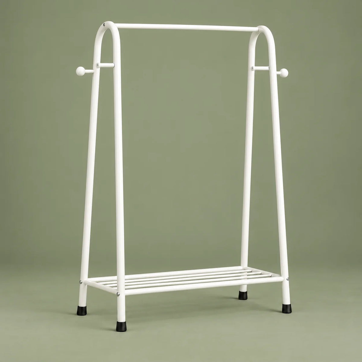Vue de face du mini dressing blanc avec barre et étagère basse sur fond vert sauge