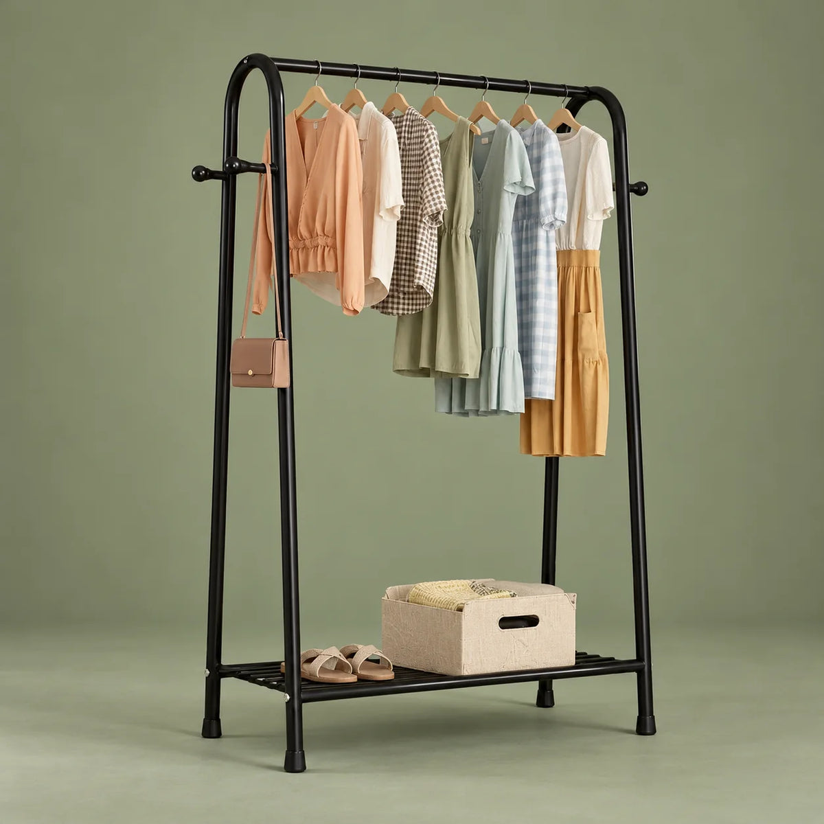 Vue de face du mini dressing noir et de son étagère basse sur fond vert sauge