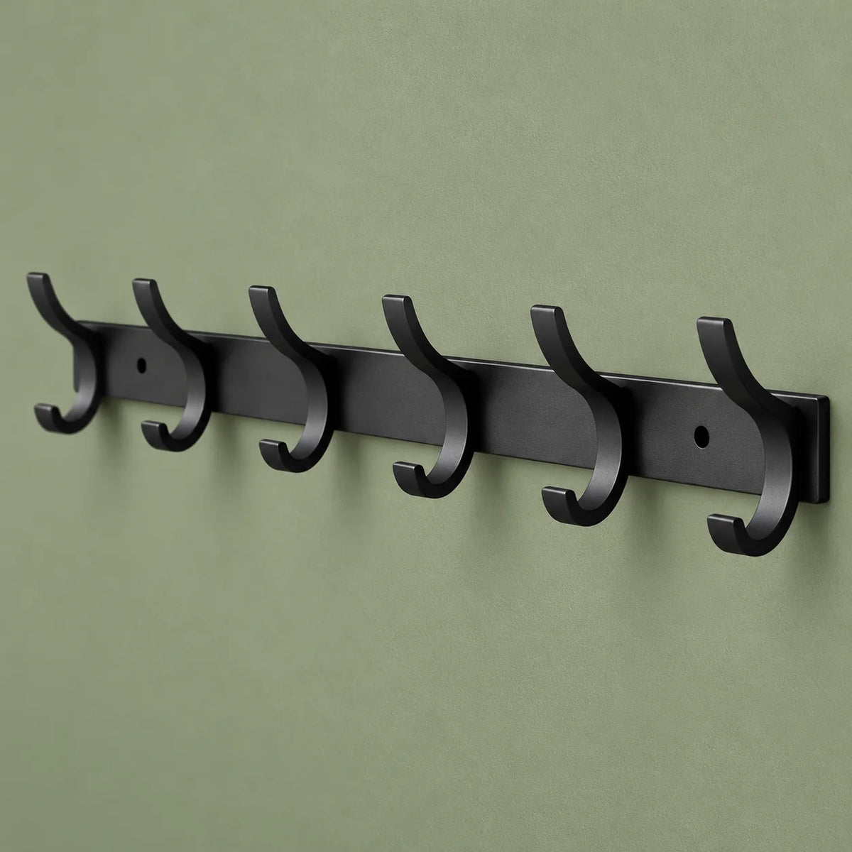 Vue oblique montrant la profondeur des six crochets du porte-manteau noir sur fond vert sauge