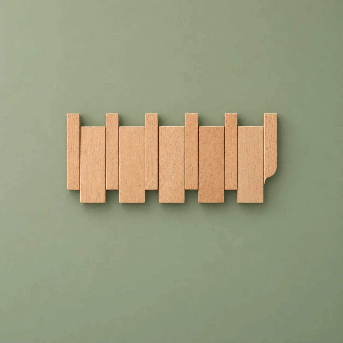 Vue entière de face du porte-manteau mural compact en bois clair sur fond vert sauge