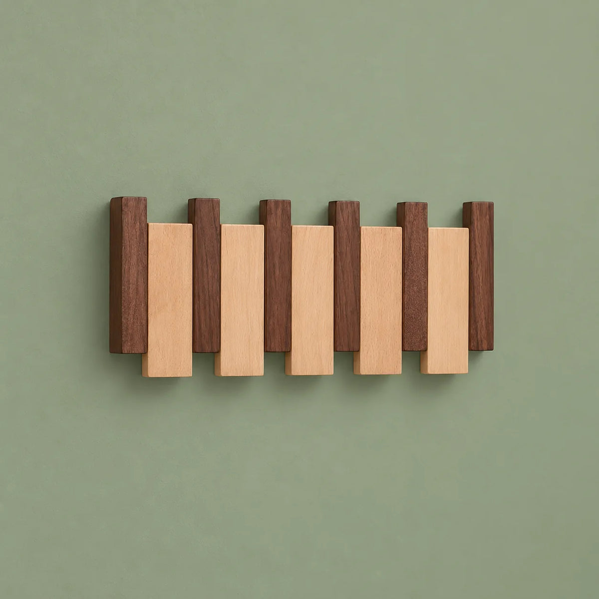 Vue de face du porte-manteau en bois bicolore à lames alternées sur fond vert sauge