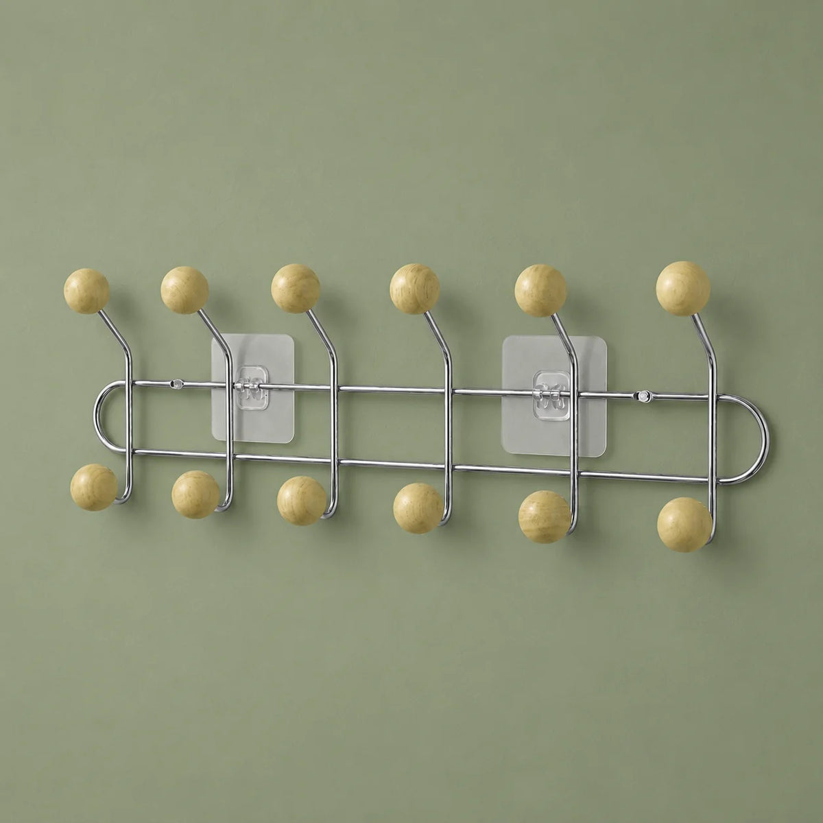 Porte-manteau mural chromé à six bras et douze boules bois jaune crème sur fond vert sauge