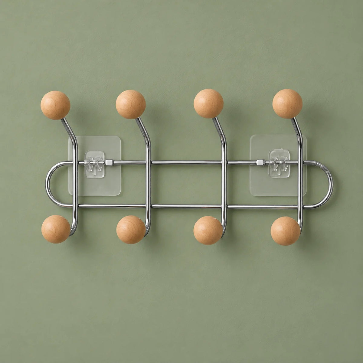 Porte-manteau mural chromé à huit boules bois abricot sur fond vert sauge