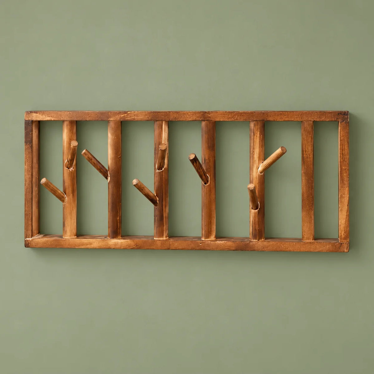 Vue de face du porte-manteau mural Tige Bois marron et de ses huit crochets sur fond vert sauge