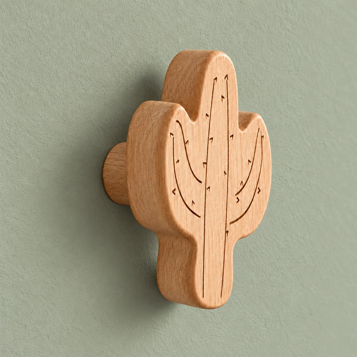Vue de biais de la patère cactus montrant son épaisseur et son support cylindrique sur fond vert