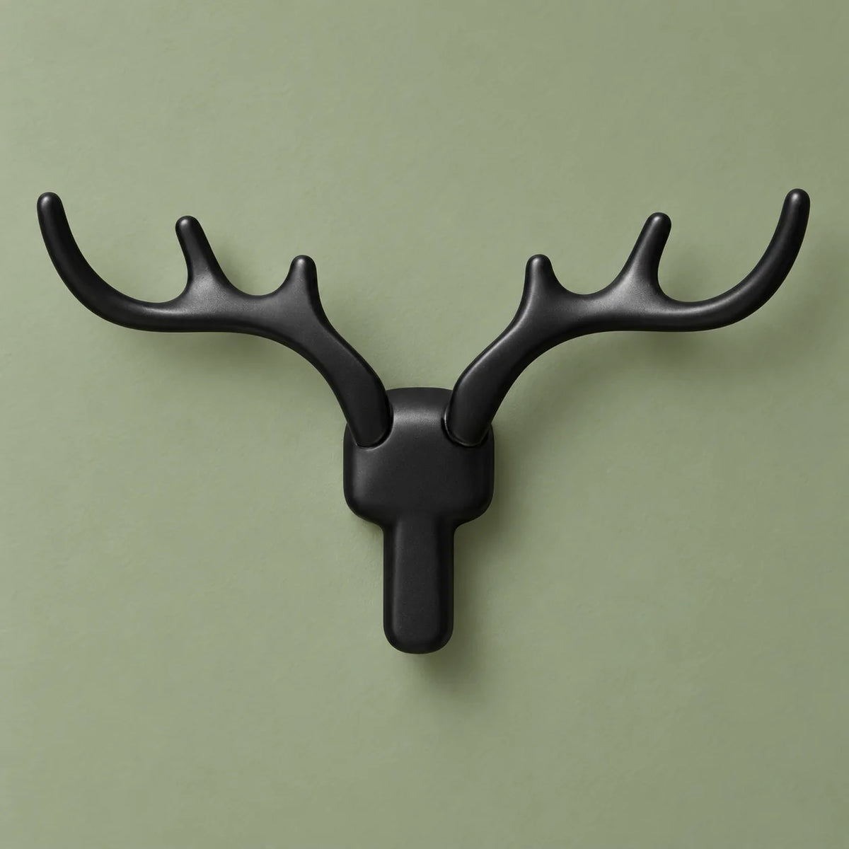 Patère cerf noire vue de face sur fond vert sauge
