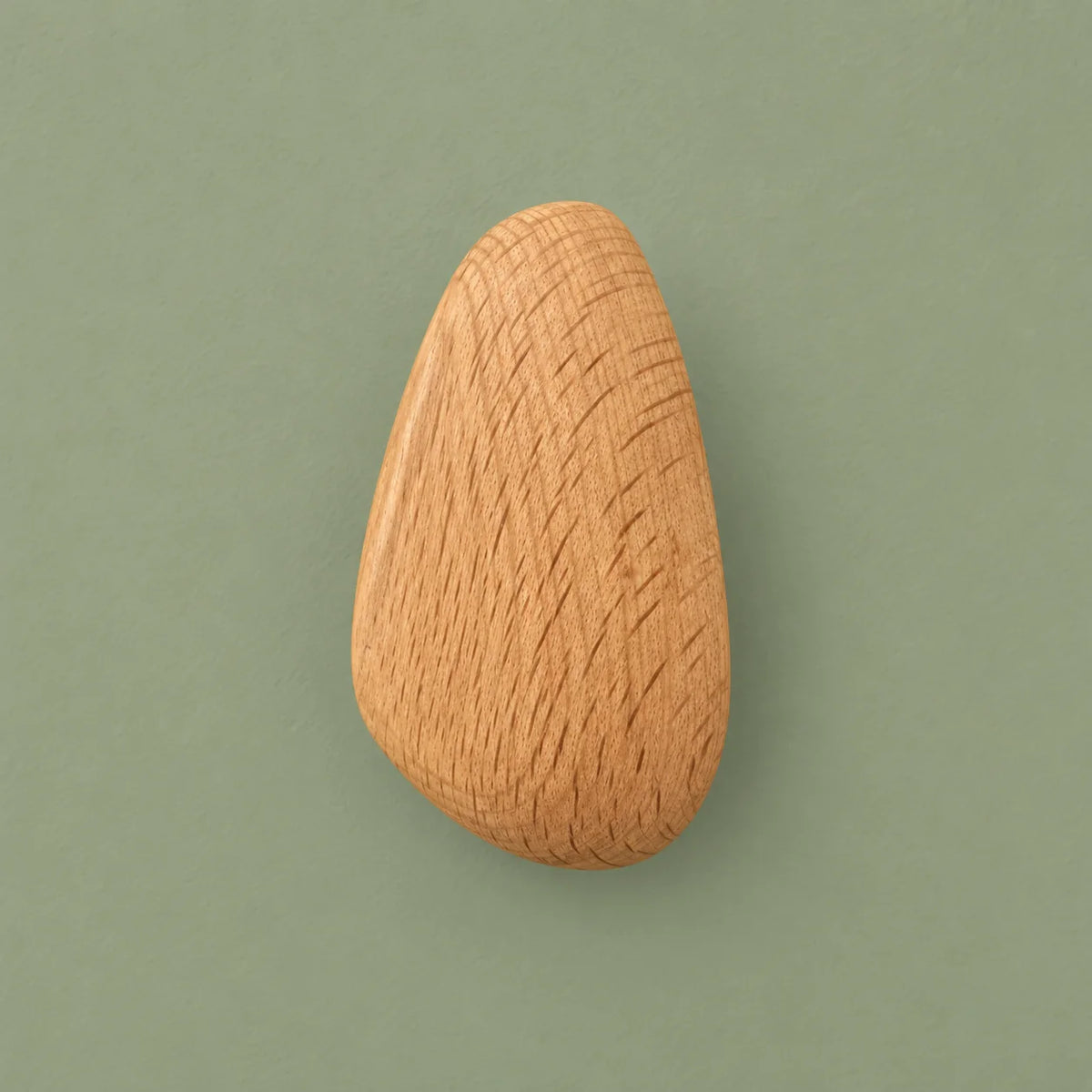 Patère ovale en bois clair vue de face sur fond vert sauge