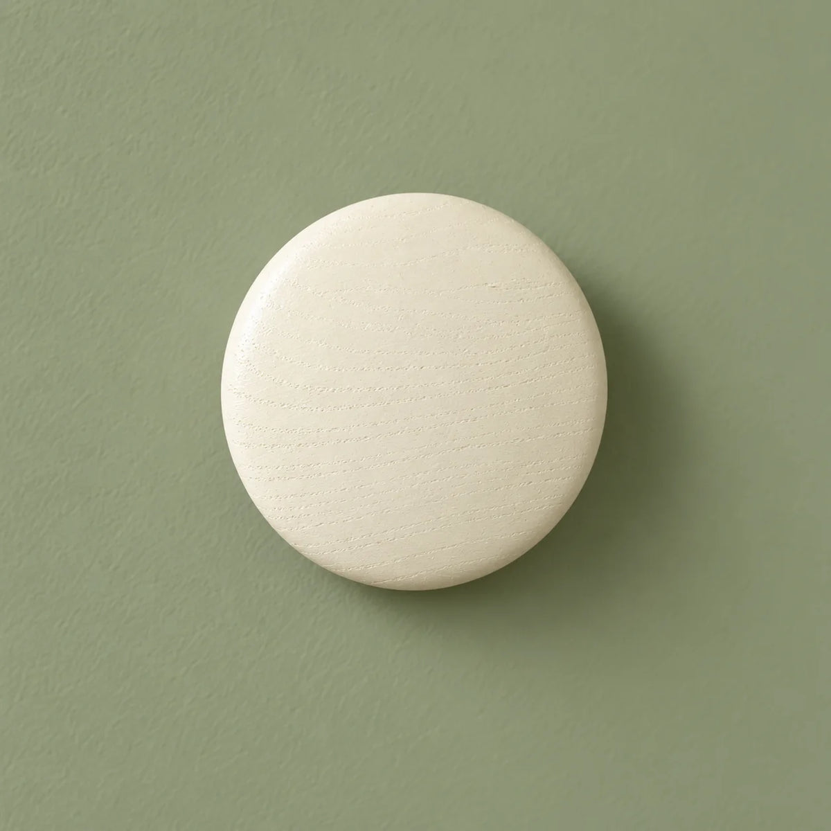 Patère ronde blanche vue de face sur fond vert sauge