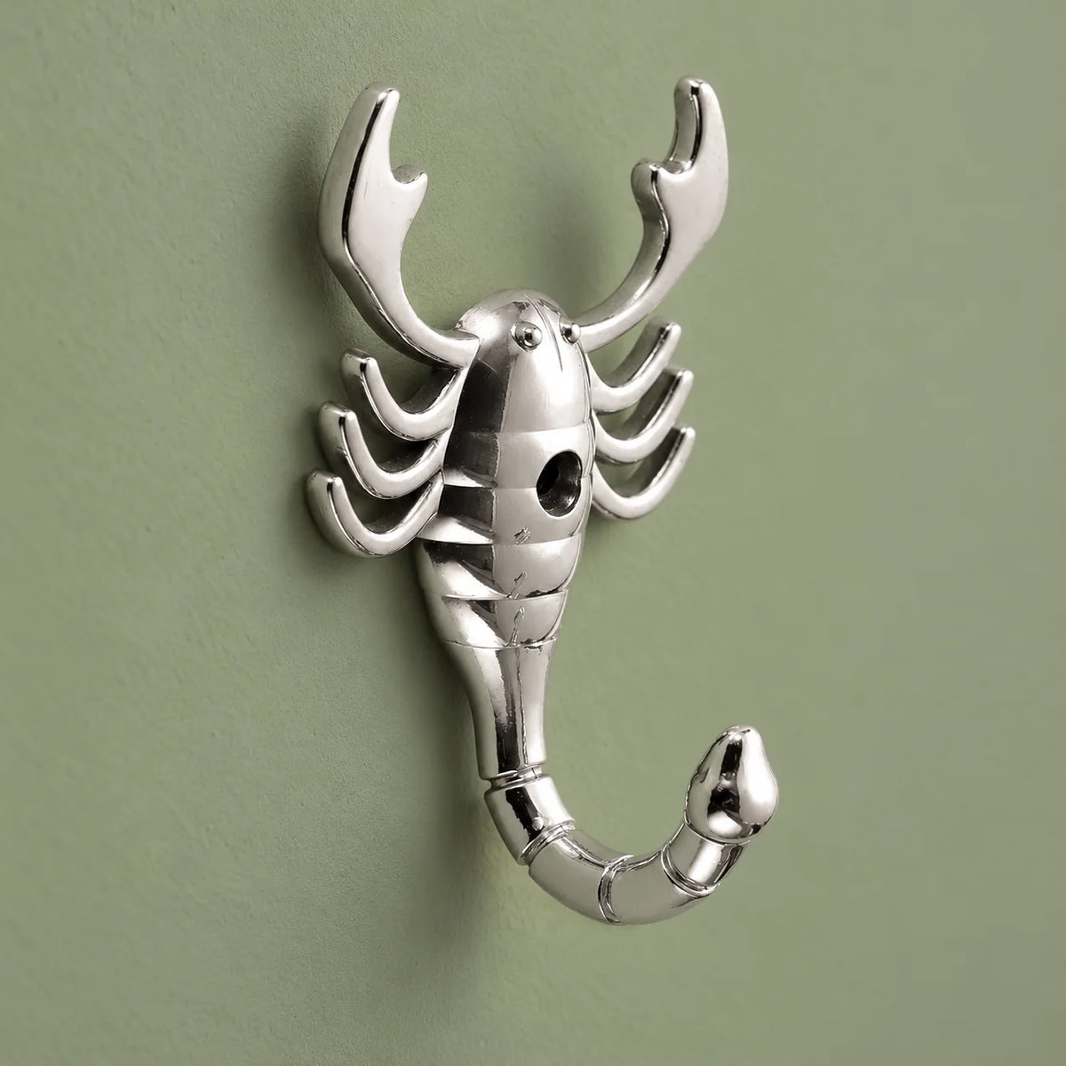 Vue de trois quarts de la patère scorpion argent montrant son relief et sa queue crochet