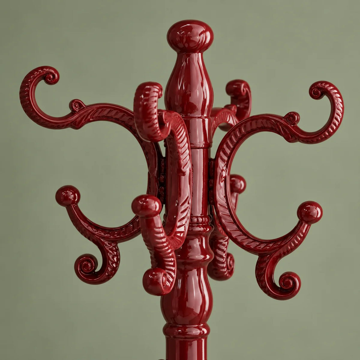 Détail des crochets ornés rouges sur fond vert sauge