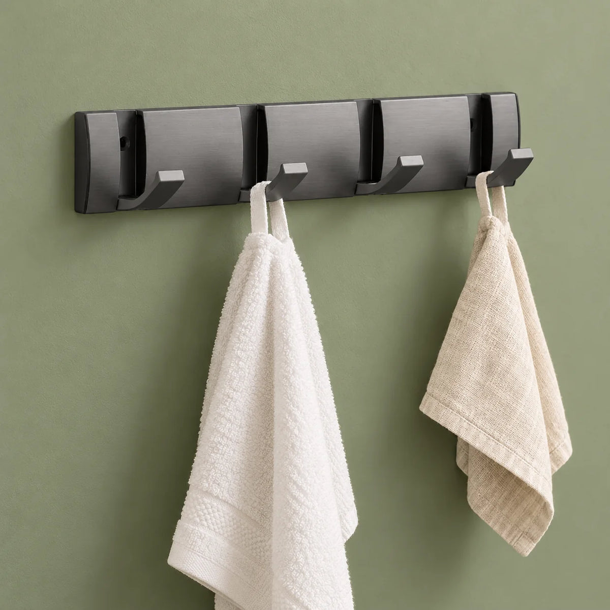 Petit porte-manteau gris avec deux serviettes suspendues sur fond vert sauge