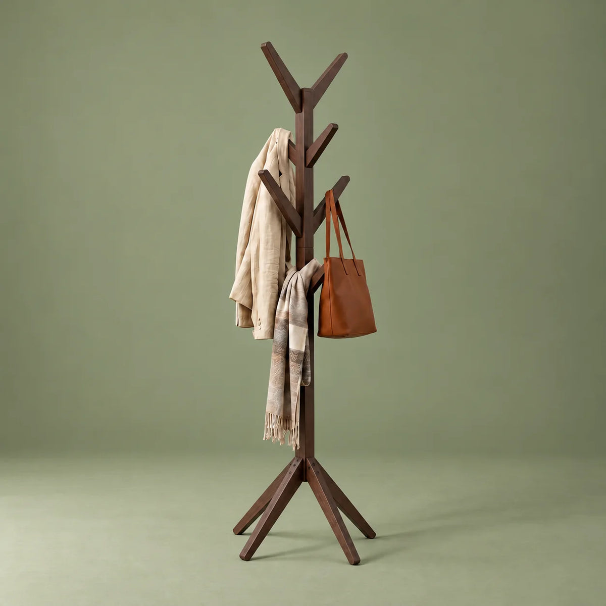 Porte-manteau arbre à huit crochets en bois foncé vu de trois quarts sur fond vert
