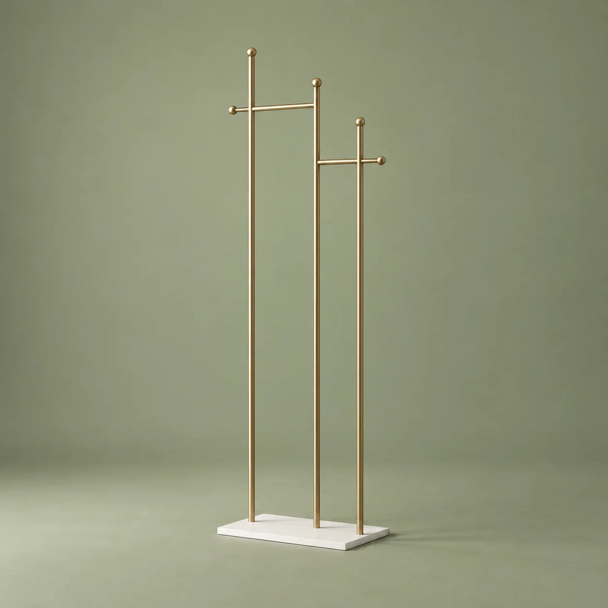 Porte-manteau sur pied à montants dorés et base blanche sur fond vert sauge