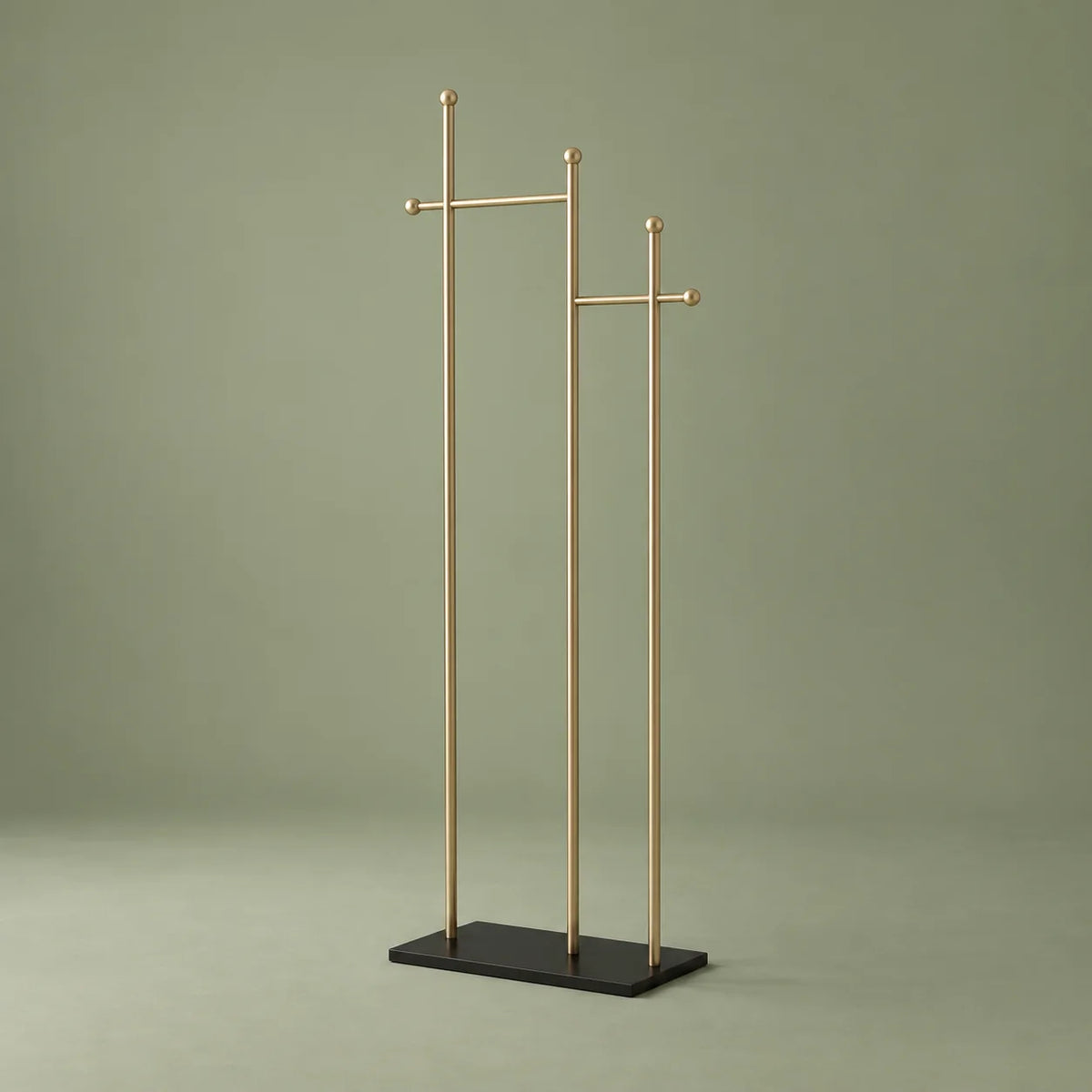 Porte-manteau sur pied à montants dorés et base noire sur fond vert sauge