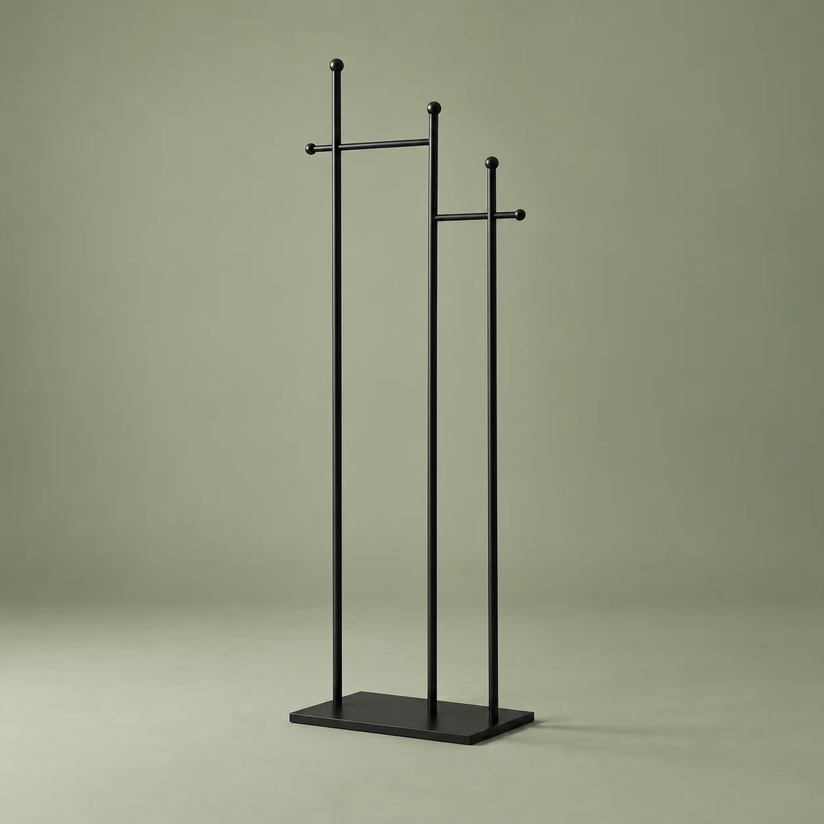 Porte-manteau sur pied noir à trois montants et deux traverses, sur fond vert sauge